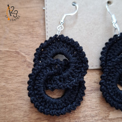 Boucles d'oreilles pendantes en coton de coloris noir.