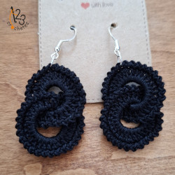 Boucles d'oreilles pendantes en coton de coloris noir.