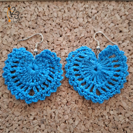 Les boucles d'oreilles fait main au crochet avec un fil coton bleu.