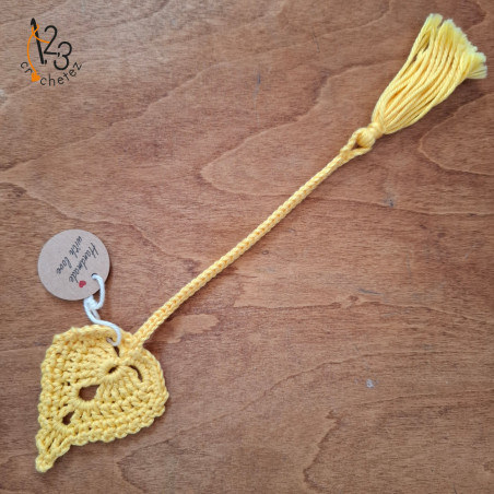 Un marque-pages en forme de feuille jaune, réalisé au crochet en Alsace.
