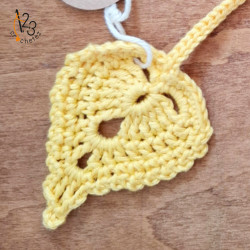 Un marque-pages en forme de feuille jaune, réalisé au crochet en Alsace.
